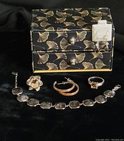 Photo showing all five pieces of sterling silver jewelry and the decorative jewelry box with a black background.