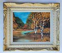 Front view of the painting in the antique wood frame showing the full landscape of river and trees with bright blue sky.