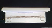 Full view of sterling silver bracelet inside white box showing the entire length and packaging