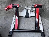Top view showing the overall compact structure of the Elite Qubo Fluid home cycling trainer, highlighting the base and arms with branding visible.