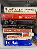 Stack of nine books including Robert Kennedy and His Times, Katharine Hepburn, Reasonable Doubt, a book by Walter Cronkite, Game Change, Terror Presidency, Truman, and another copy of Robert Kennedy and His Times.