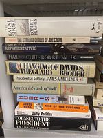Photo showing a stack of approximately 12 books with titles related to politics and history including The Fatal Shore, The Strange Career of Jim Crow, and Hail to the Chief.
