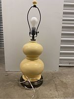 Full view of light yellow double gourd Pottery Barn lamp with metal base and attached cord.
