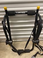 Front view of Rhode Gear trunk mount bike rack showing foam padding on support arms and securing straps with buckles.