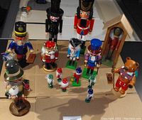Overall view of the nutcracker lot showing several wooden nutcrackers in various colorful uniforms and a bear figurine