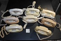 Lot of 8 vintage Princess telephones, six Bell/Western Electric rotary dial phones and two push-button models in various cream and beige colors, cords attached.