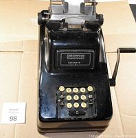 Front view of black Underwood Sundstrand manual adding machine showing number keys and crank handle.