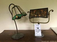 Two vintage small table lamps on wooden surface, showing designs and bases