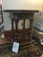 Full view of the dark wood octagonal table showing its carved edges and turned legs.