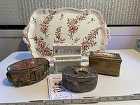 Full set of vanity tray, porcelain piano lipstick holder, filigree box, felt-lined box, and music box arranged together with ruler for scale