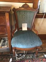 Front view of Victorian ladies chair showing detailed wooden frame and blue moire upholstered seat and backrest.