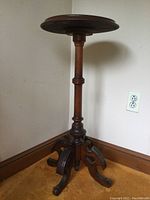 Full view of the Victorian wooden fern stand showing the round top, central column, and curved carved legs on the base.