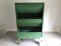 Front view of green vintage metal produce bin showing two internal trays and handle dividing top section.