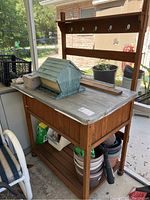 Cedar wooden potting station with hooks and wooden surface, bird house and other items on top