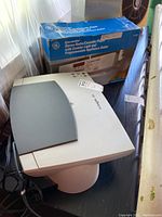 GE Spacemaker radio cassette player box next to Lexmark printer, showing item packaging and model details.