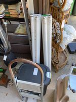 Photo showing four fluorescent light tubes, folded metal step stool, and plastic garbage bin grouped together