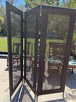 Three hinged foldout panels in a zig-zag position showing dark brown plastic wicker-like lattice design.