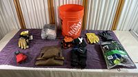 Full assortment of safety harness gear including gloves, respirator, tool belt, and bucket placed on purple cloth for display