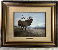 Full view of the framed artwork showing an elk in a natural setting with matting, frame, and brass name plaque visible.