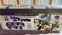 Box of Slim Cycle Stationary Bike showing product branding, images, features, and model usage positions (reclining and upright).