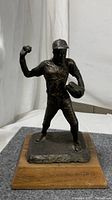 Frontal view of full statue and wooden base