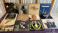 Photo showing 11 vinyl records with original jackets arranged on table, including well-known albums from The Byrds, CCR, The Doobie Brothers, Stevie Wonder, Rod Stewart, Neil Young, and Chicago.