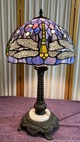 Full view of lamp showing stained glass shade and metal base with onyx accent