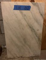 Front view of rectangular marble piece with white and grey veining.