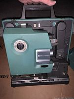 Side view of the Bell & Howell 1592 projectors showing power dial and lens details