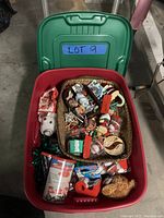 Top view of red bin with open green lid, showing basket filled with assorted Christmas ornaments and various decorations around it