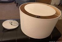 Fabric drum shade with metal ceiling plate on dark surface, showing size and condition