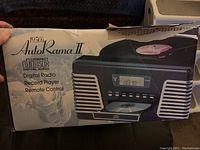 Box front showing product image and features including digital radio, record player, compact disc, and remote control