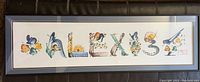 Framed decorative name print spelling ALEXIS with Japanese style illustration details.