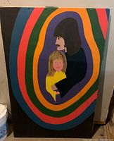 Full view of large acrylic painting showing man and child in concentric colorful bands