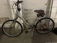 Side profile of silver Schwinn Sierra women's bicycle leaning on kickstand, showing the full frame, tires, and saddle.