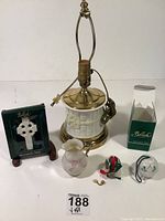 Full view of the lot showing all five pieces: lamp made from bamboo biscuit jar, boxed Celtic cross, basket ornament, bell ornament, and creamer.