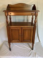 Front view of medium brown dry sink side table with back splash and closed cabinet