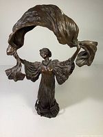 Front view of lamp showing female figure and draped canopy