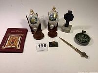 Full lot view showing all 8 pieces: ceramic dish, two Irish Blessings ornaments on stands, brass Celtic cross letter opener, two black Celtic crosses with marble bases, and ladies scarf.