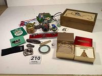 Full view of the lot spread on a white table showing cloisonne clutch, jewelry boxes, magnifying glass, and other items