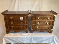 Two Lane campaign style wood side tables with three drawers each, brass drawer pulls, and brass corner accents.