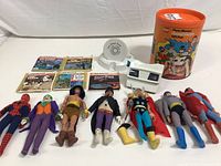 Overview of seven Mego action figures laid out with View-Master cylinder, viewer and reel kits