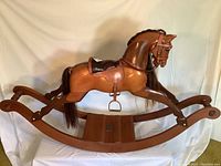 Side view of full wooden rocking horse showing curved rockers, body and mane