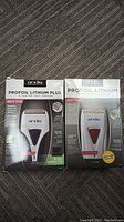 Photo showing two boxed Andis ProFoil Lithium Plus Titanium foil shavers, highlighting brand and packaging condition.