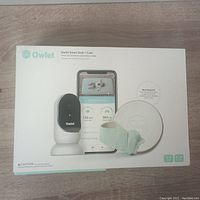 Box of Owlet Smart Sock + Camera in factory packaging showing product features.