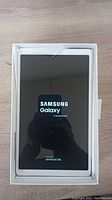 Tablet in packaging powered on showing Samsung boot screen