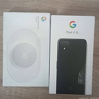 Front view of two sealed factory boxes: Nest Thermostat Trim Kit and Pixel 4 XL