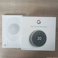 Front view of sealed Nest Learning Thermostat and trim kit boxes