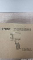 Closed cardboard box with printed image and Bentsai branding, indicating handheld inkjet printer inside.