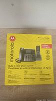 Front of Motorola ML1250 retail box showing product image and features including 4-line phone system, call waiting, digital answering system, and line status indicators.